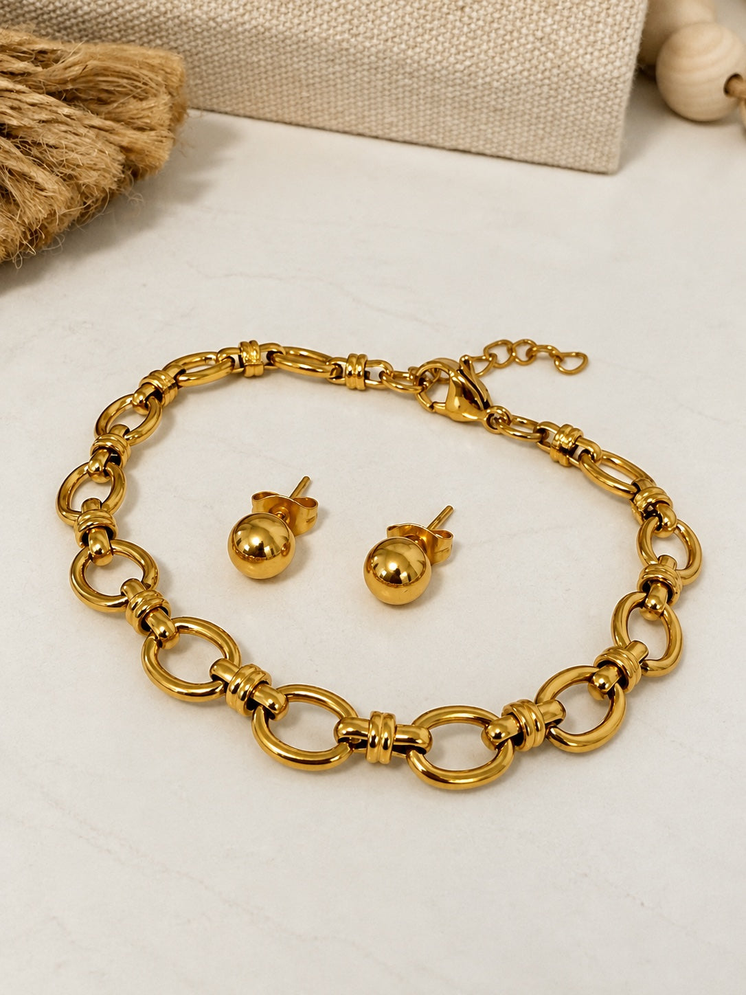Set bolitas y pulsera oro en la mesa